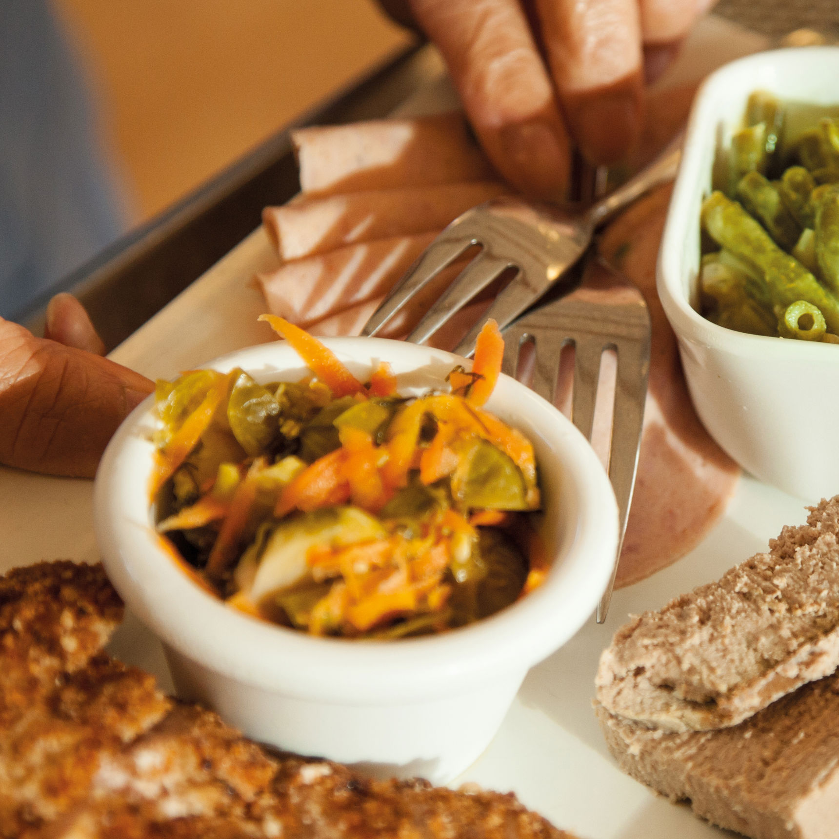 Mad på etn tallerken. Der er blandt andet grønne bønner, kødpålæg, leverpostej og brød på tallerkenen.