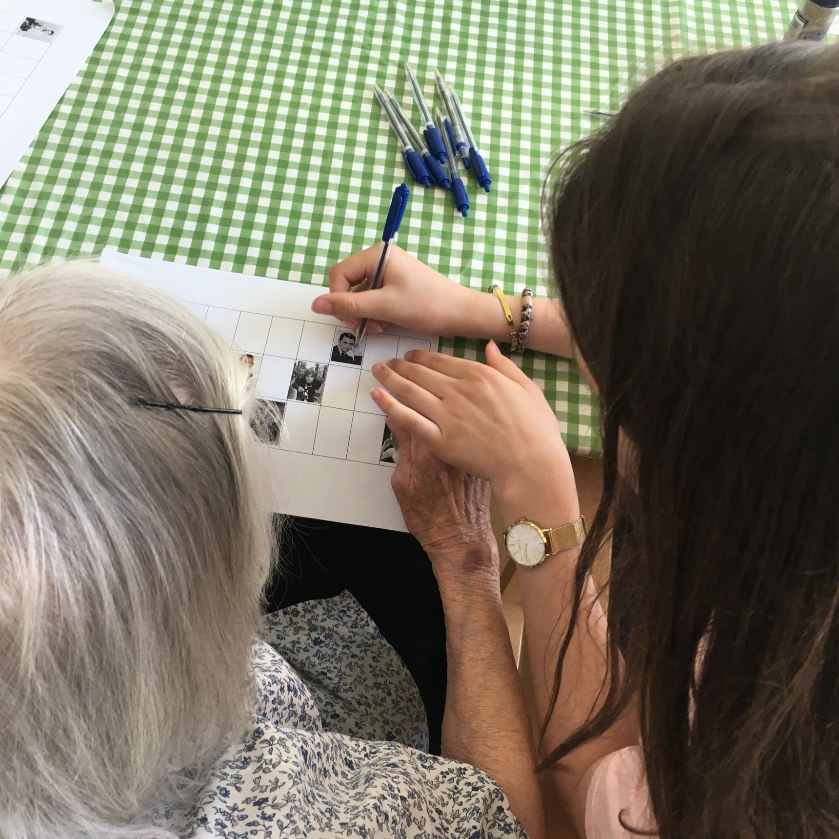 En medarbejder hjælper en beboer med at spille banko.